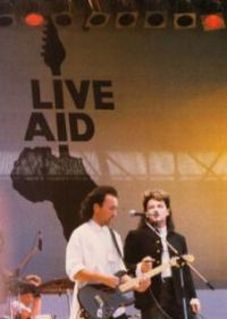 The Edge e Bono no Live Aid  e Larry ao fundo